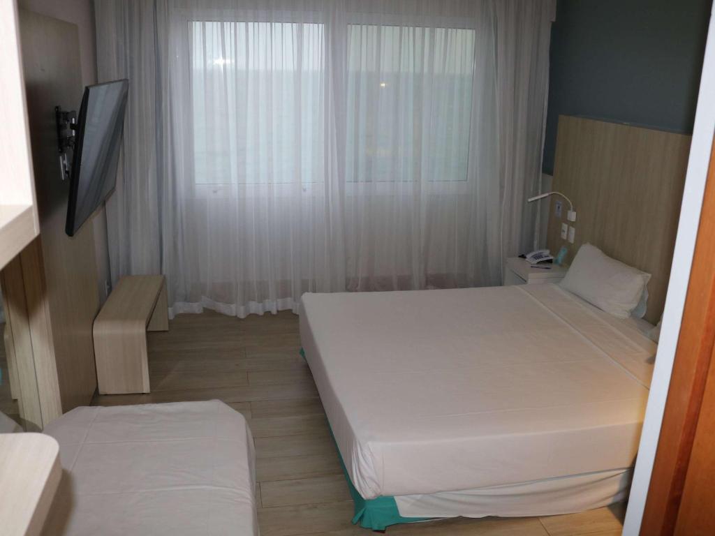 Cama ou camas em um quarto em Mercure Salvador Rio Vermelho