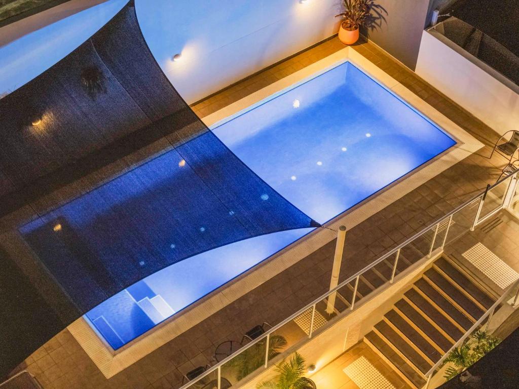 麥覺理港的住宿－麥誇裡港中心美居酒店，大楼内大型游泳池的顶部景色
