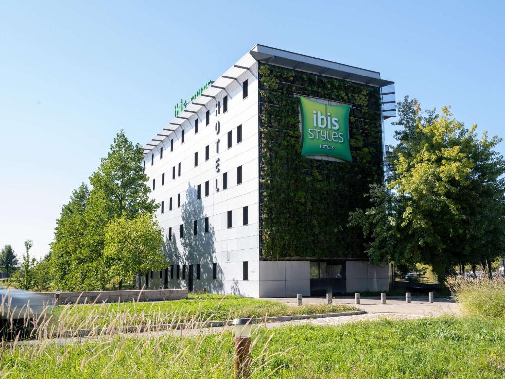 un bâtiment avec un panneau sur son côté dans l'établissement ibis Styles Romans-Valence Gare TGV, à Alixan