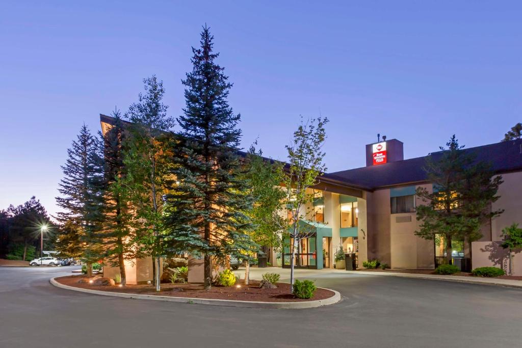 a hotel with trees in front of a building at Best Western Plus Inn of Williams in Williams