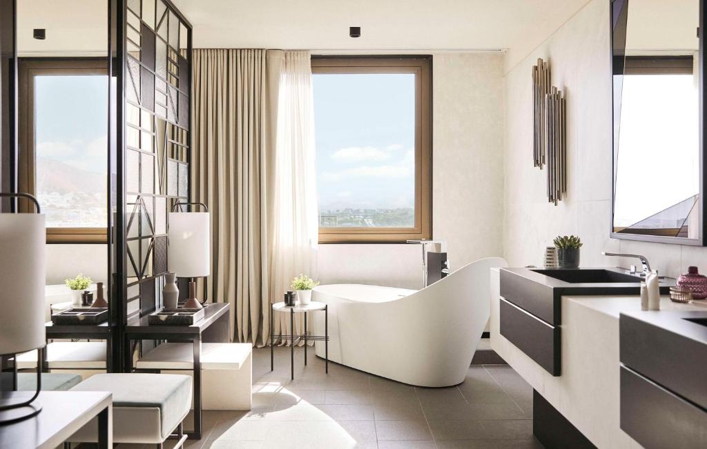 a bathroom with a white tub and a sink at Grand Hyatt Barcelona in Barcelona