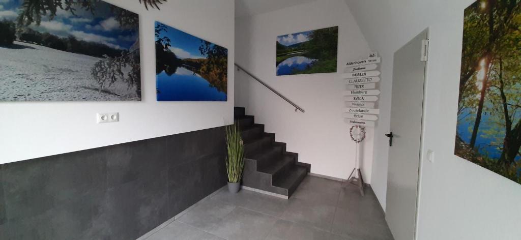 a staircase in a room with pictures on the walls at VivaNatura EifelferienStudio in Simmerath