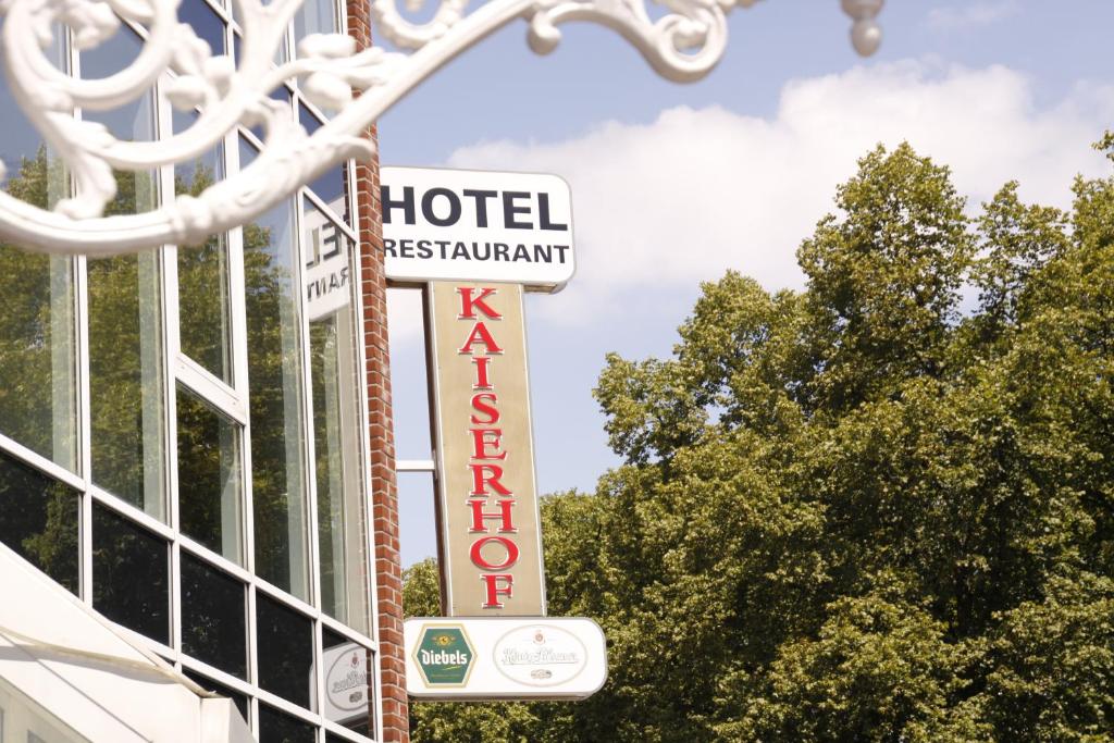 a sign for a hotel restaurant and a hotel sign at Hotel Kaiserhof Wesel in Wesel