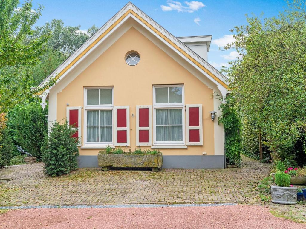 Una casa con persianas rojas. en Picturesque Holiday Home in Oldenzaal with Jacuzzi en Oldenzaal