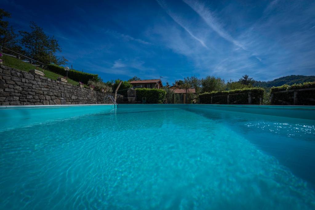 een groot blauw zwembad voor een huis bij La Vecchia Fornace - Abetone, authentic farmhouse with private pool in Pian degli Ontani