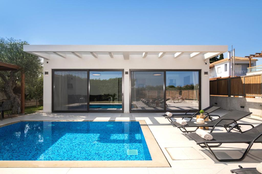 una piscina in una villa con vista di Oresteia Exclusive Villa, a Sublime Retreat, By ThinkVilla a Tragaki
