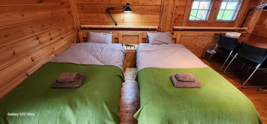 una habitación con 2 camas en una cabaña en まちなかlodge ほしとたきび Lodge in city Hoshi to Takibi, en Ōmuta