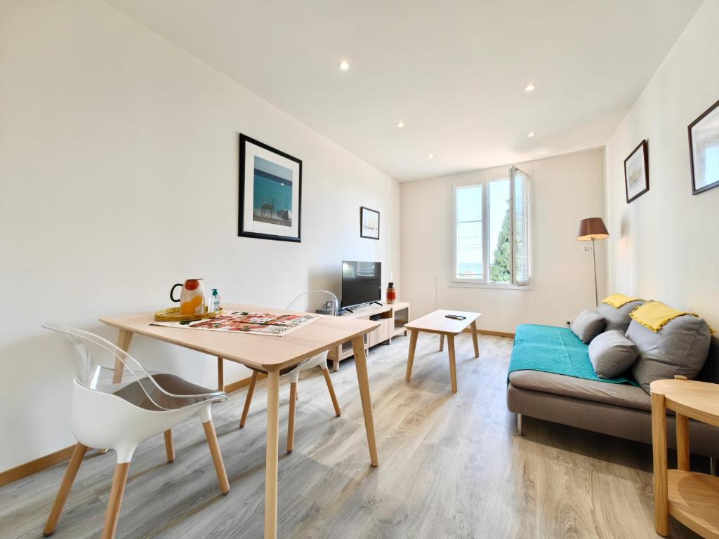 un salon avec une table et un canapé dans l'établissement Foch 3 by Booking Guys, à Villefranche-sur-Mer