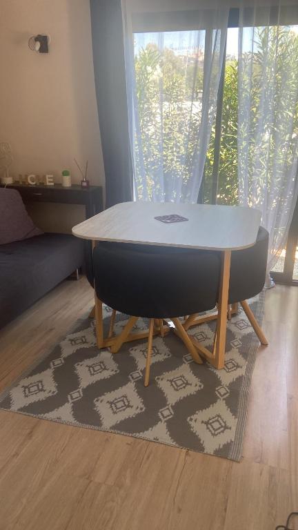 einen Tisch und zwei Stühle im Wohnzimmer in der Unterkunft Maison cosy au calme in La Colle-sur-Loup
