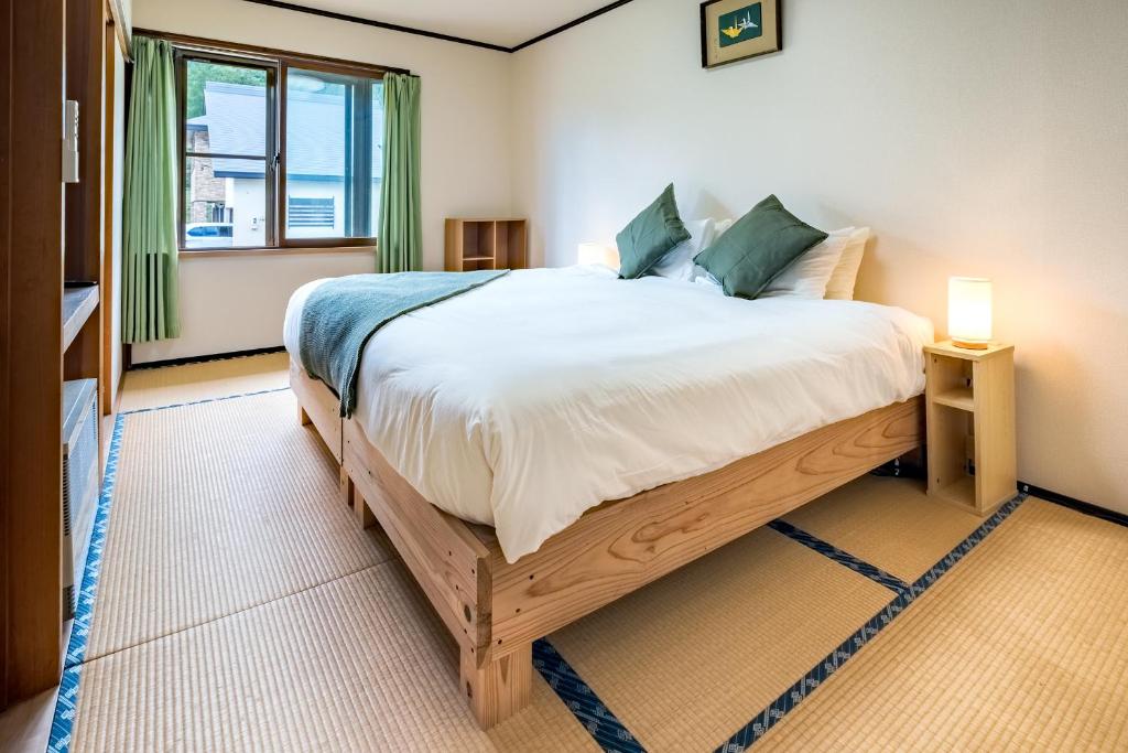 a bedroom with a large bed and a window at Iimori Vista in Hakuba