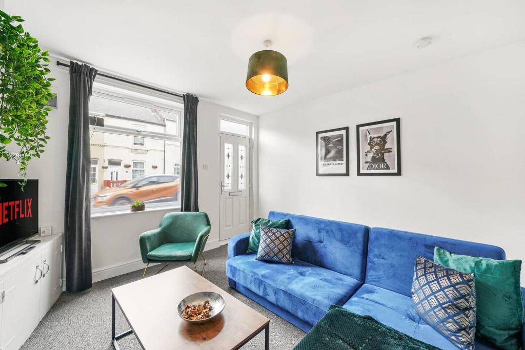 uma sala de estar com um sofá azul e uma mesa em Stylish 4 Bed House in Yorkshire - Sleeps 9 em Hickleton
