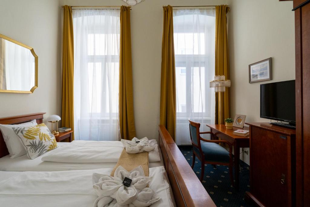 Habitación de hotel con 2 camas, escritorio y TV. en Hotel-Zimmer direkt am See, en Gmunden
