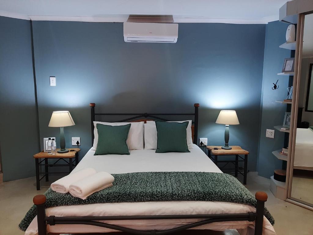 a bedroom with a bed with a blue wall at Leadwood Lodge in Tzaneen