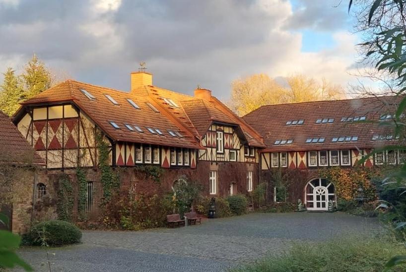 a large brick building with a red roof at Rittergut Haus Laer in Bochum