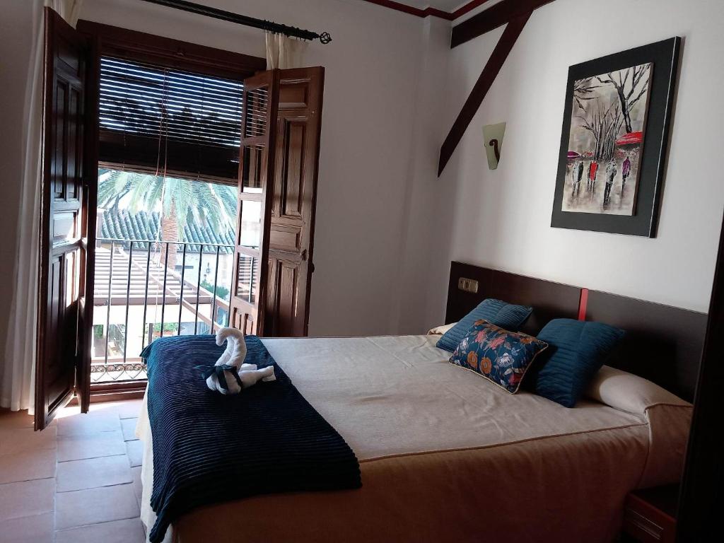 - une chambre avec un lit et une grande fenêtre dans l'établissement Palacio del Gobernador, à Moral de Calatrava