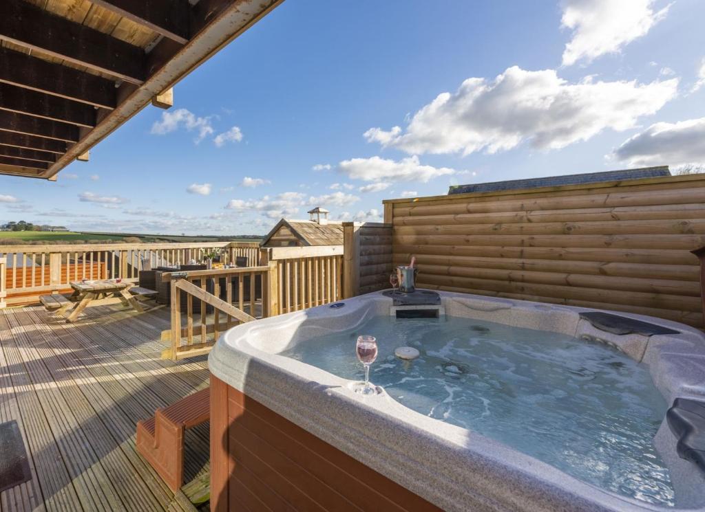 a hot tub on the deck of a house at Lodge 40, Retallack Resort & Spa in Saint Columb Major