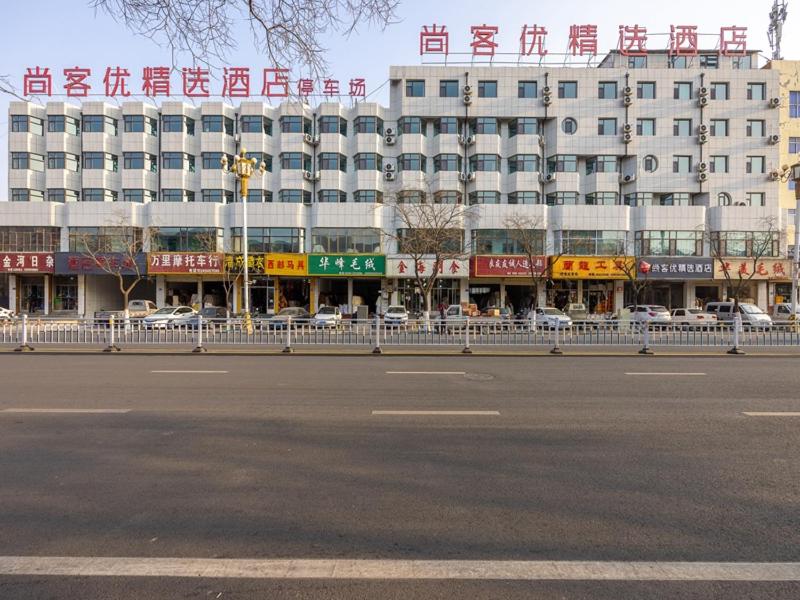 un gran edificio blanco con escritura china. en Thank Inn Plus Linxia Bafang Shisanxiang, en Linxia
