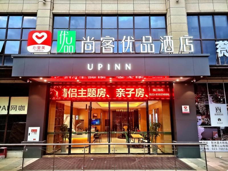 Thank Inn Plus Chongqing Pengshui Yujing Jiangshan في Pengshui: مدخل لمبنى عليه لافتات