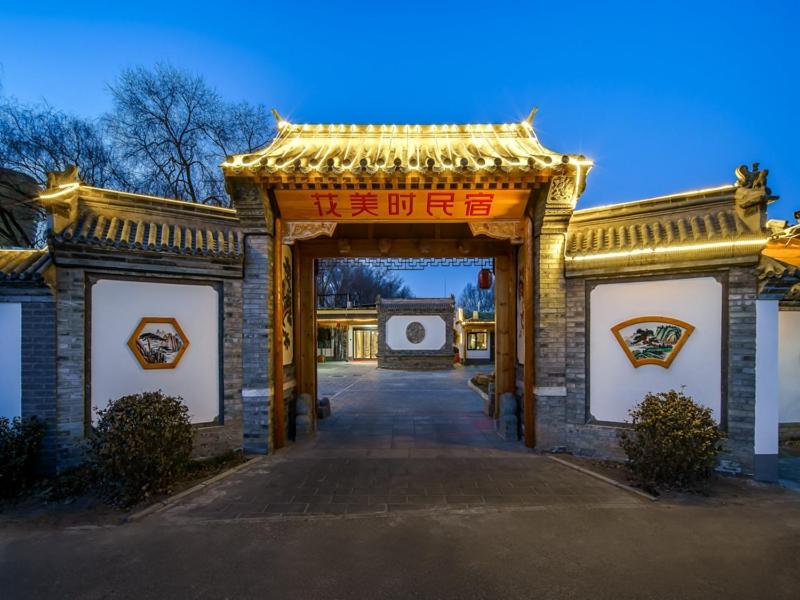 una entrada a un edificio con una puerta con un arco en Feronia Hotel Beijing Bird's Nest Datun Road en Beijing