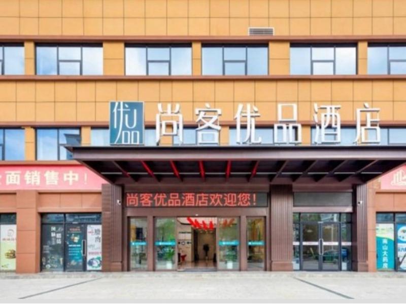 een gebouw met een bord aan de voorkant bij Thank Inn Plus Hanzhong High-Speed Railway Station in Hanzhong