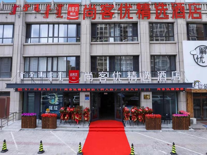 un bâtiment avec un tapis rouge devant lui dans l'établissement Thank Inn Plus Baotou Kundulun District University of Science and Technology, à Baotou