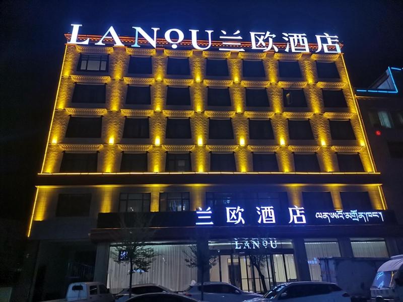 um edifício iluminado com um sinal em LanOu Hotel Longjiang Road Shigatse em Shigatse