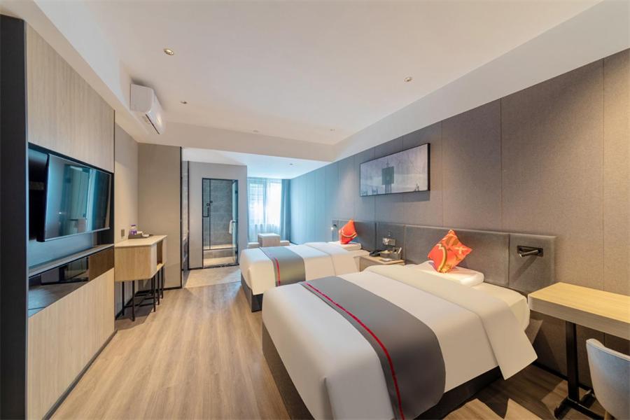 a hotel room with two beds and a flat screen tv at Thank Inn Shaoxing Luxun Hometown in Shaoxing