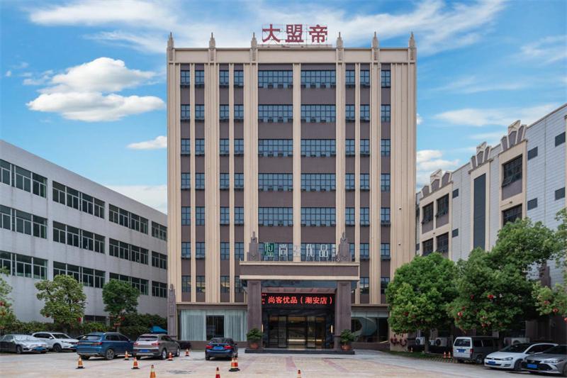 ein großes Gebäude mit davor geparkt in der Unterkunft Thank Inn Plus Chaozhou Caitang Lotus in Xialian