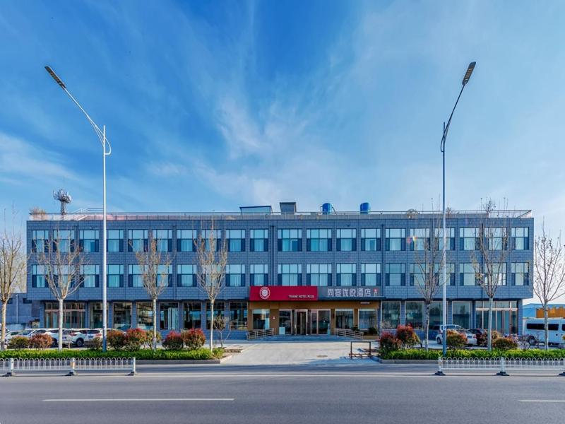 a large blue building with a street in front of it at Thank Inn Linyi Jiaxing Fruit Market in Linyi