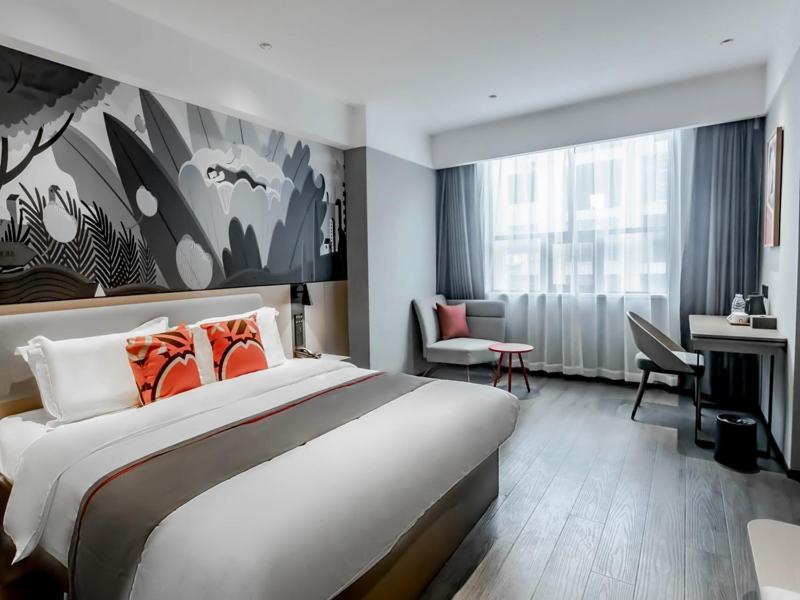 Pokój hotelowy z dużym łóżkiem i biurkiem w obiekcie Thank Inn Hengyang Leiyang City Jinhua Road w mieście Leiyang