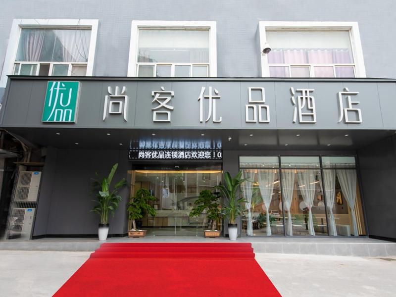 a building with a red carpet in front of a store at Thank Inn Plus Jiaozuo Jiefang District Heping Street in Jiaozuo