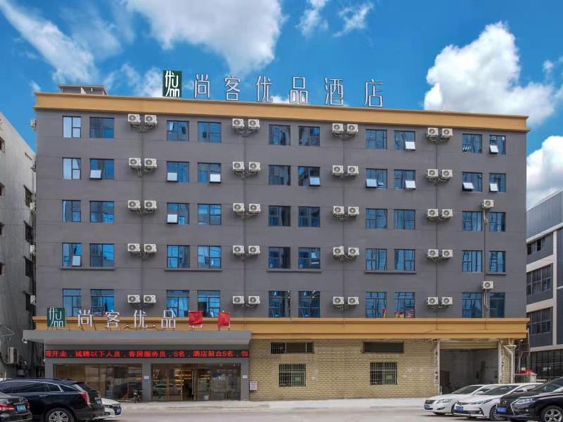 um grande edifício com uma placa em cima em Thank Inn Plus Dongguan Dalingshan em Dongguan