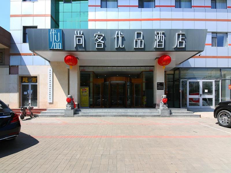 un edificio con un cartello sulla parte anteriore di Thank Inn Plus Shijiazhuang Xinhua District West Beierhuan Road a Shijiazhuang