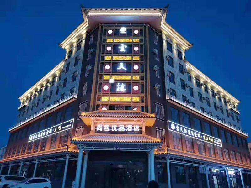 喀什的住宿－尚客优品喀什疏勒四十一团草湖镇酒店，一座高大的建筑,旁边灯火通明