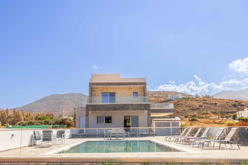 a villa with a swimming pool and a house at Andriana by the Sea in Pomos