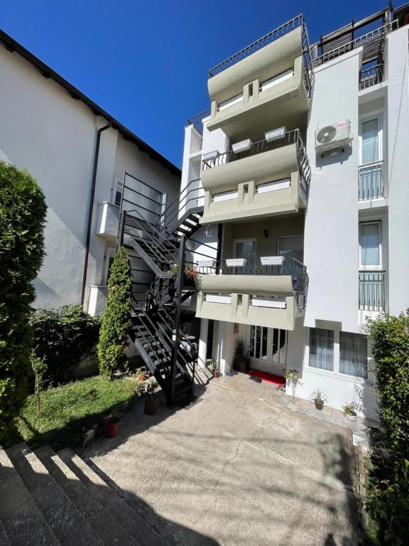 an apartment building with a spiral staircase in front of it at Sky Hostel in Peje
