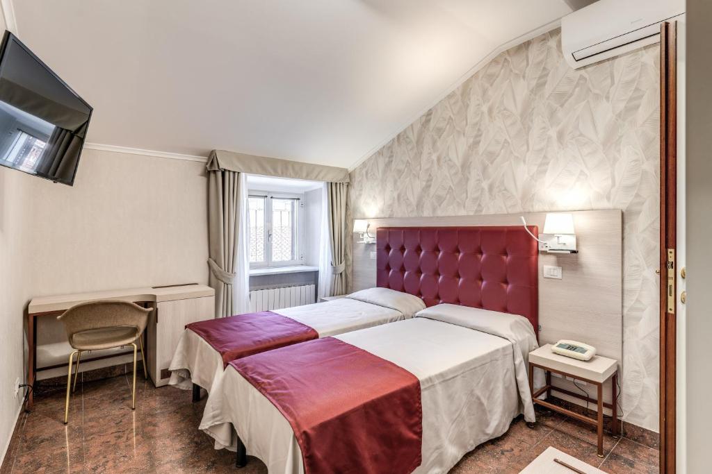 ローマにあるホテル ミロのベッドとテレビ付きのホテルルーム