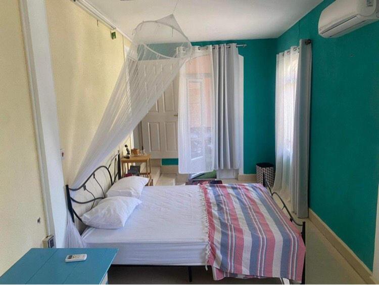 una camera da letto con un letto con copriletto bianco di Residence Mish a Mahébourg