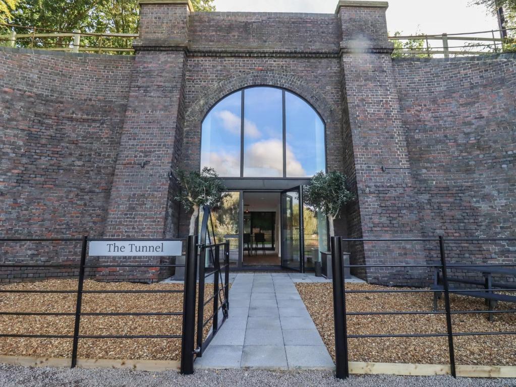 una entrada a un edificio de ladrillo con un cartel que lee el inmortal en The Tunnel at Bridge Lake Farm and Fishery en Banbury