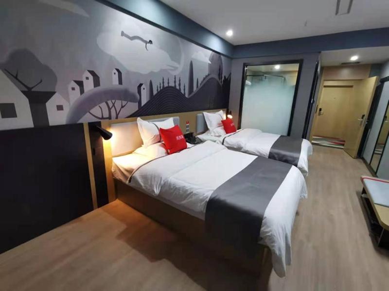 um quarto com duas camas e um quadro na parede em Thank Inn Plus Korla Saybag Market em Korla