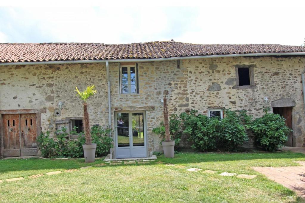 a stone house with a door in the yard at Panissac in Berneuil
