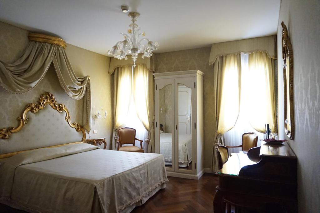 a bedroom with a bed and a chandelier at Hotel Orsaria in Venice