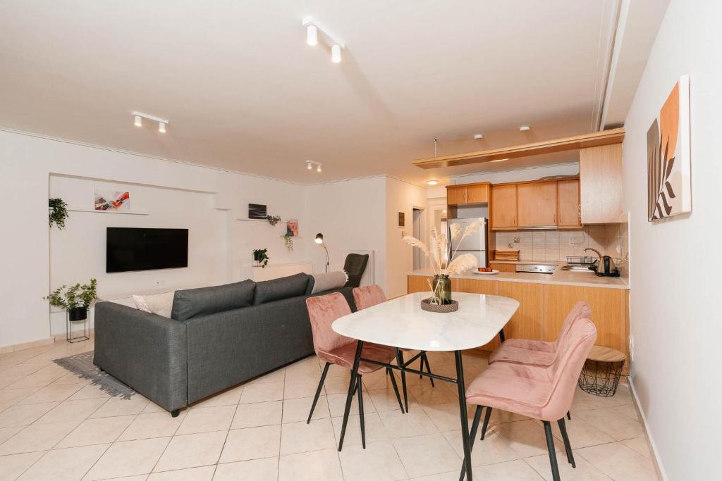 een woonkamer en keuken met een bank en een tafel bij Phaedrus Living: Cozy Flat Koukaki in Athene