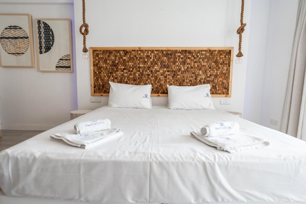 a bedroom with a white bed with towels on it at Blue Harbour Boutique in Ayia Napa