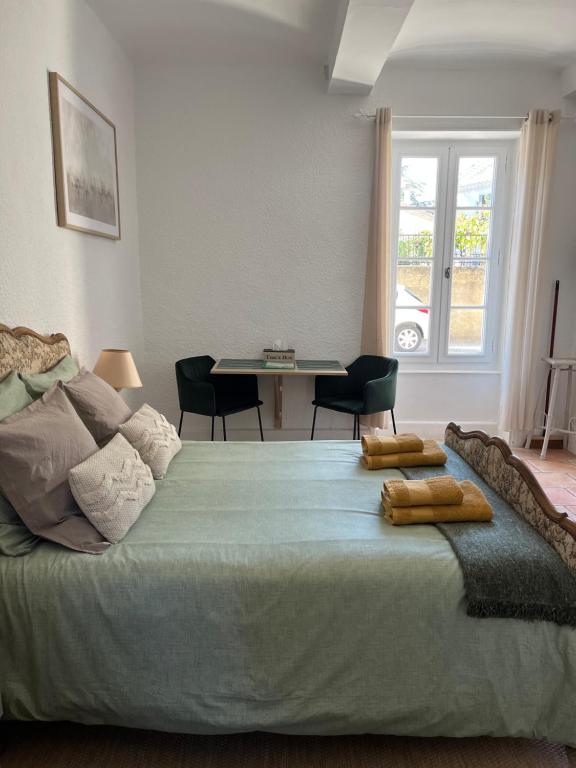 um quarto com uma cama com uma mesa e cadeiras em Au Petit Faubourg em Grignan