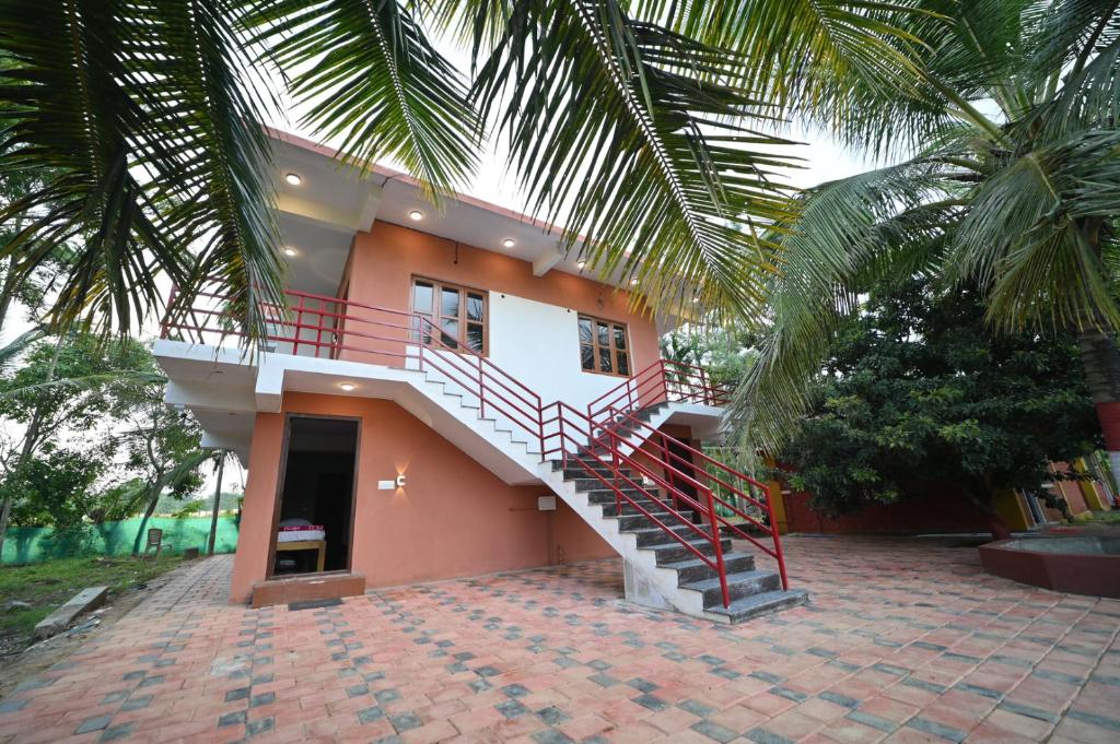 a house with a staircase in front of it at Coorg HomeStay Resort in Kushālnagar