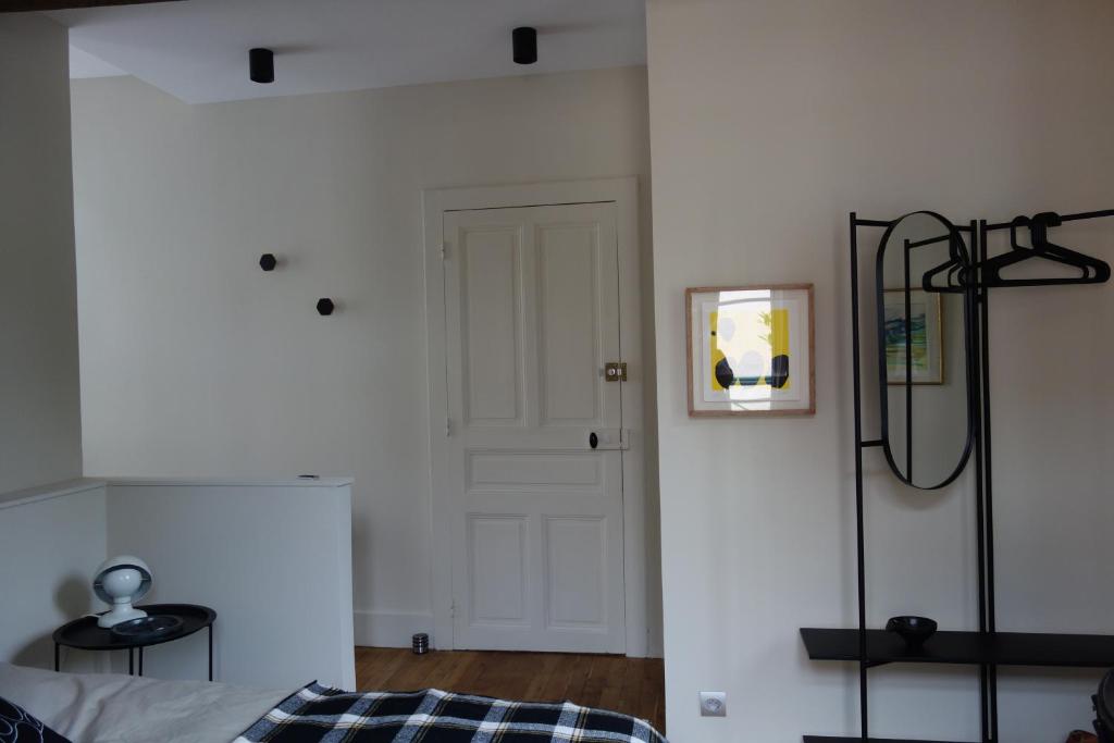 a bedroom with a bed and a white wall at la maison haute in Toucy