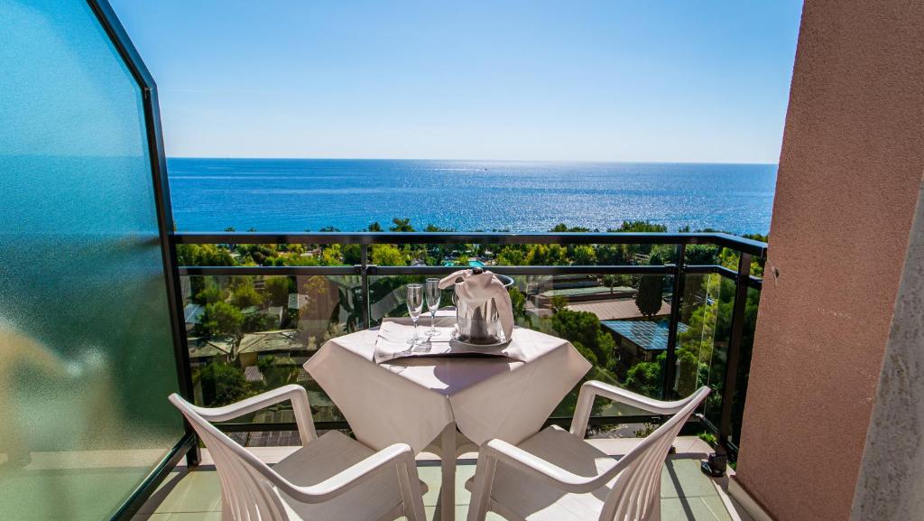 een tafel en stoelen op een balkon met uitzicht op de oceaan bij Bobby Executive in Sanremo