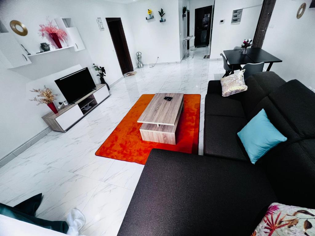 een woonkamer met een zwarte bank en een salontafel bij LUXE Appartement in Dakar