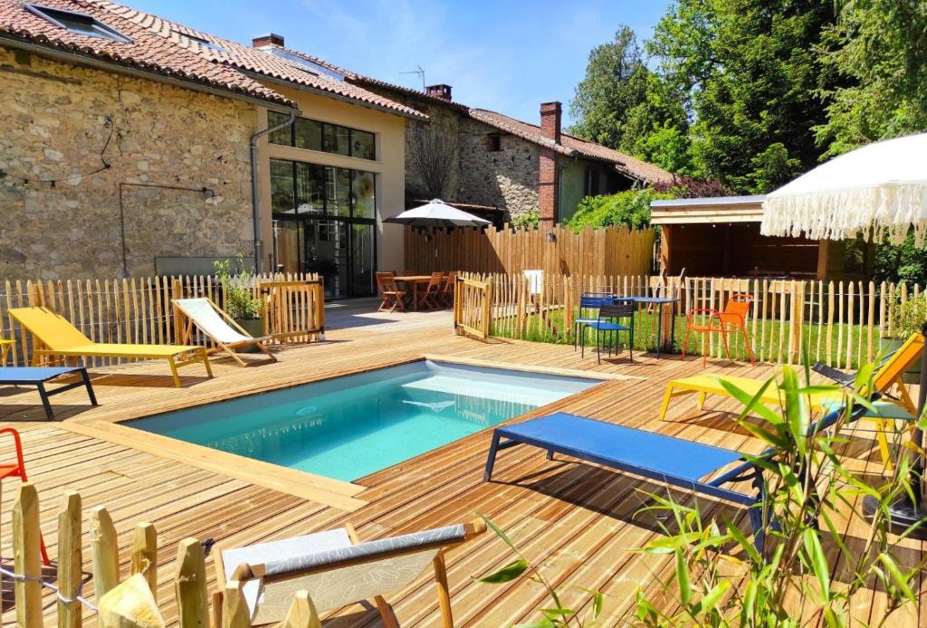 a backyard with a swimming pool and a wooden deck at La cle des champs 